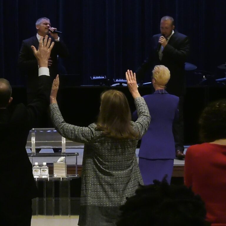 Sunday Morning Worship with Hands Raised in Praise
