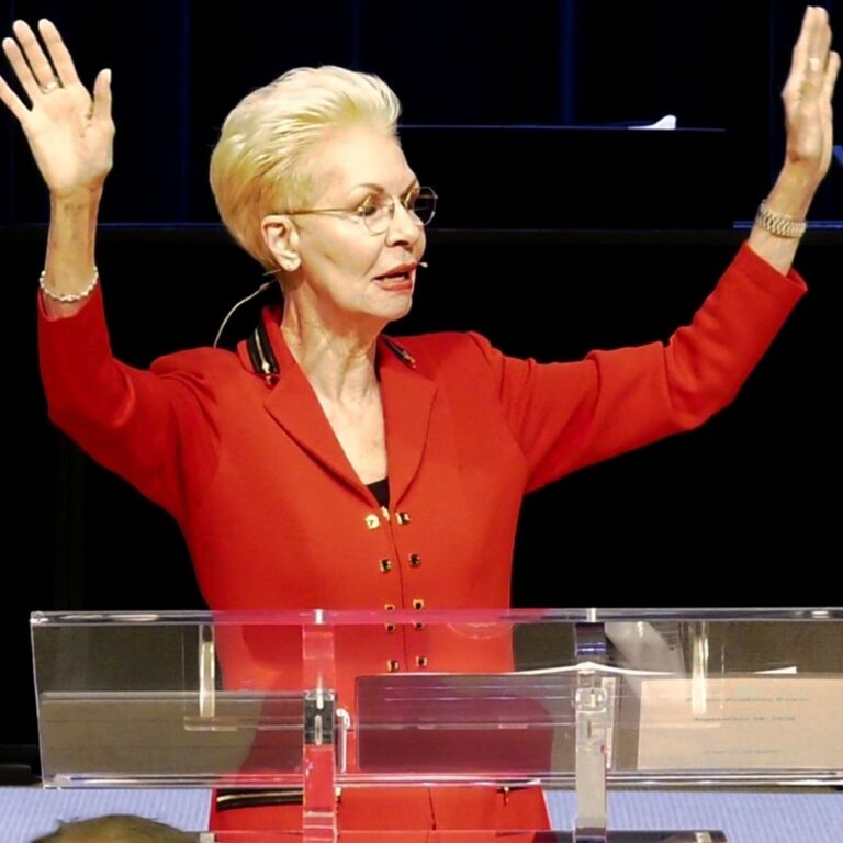 Pastor Cheryl S Jackson Red Suit Hands Raised in Prayer and Praise